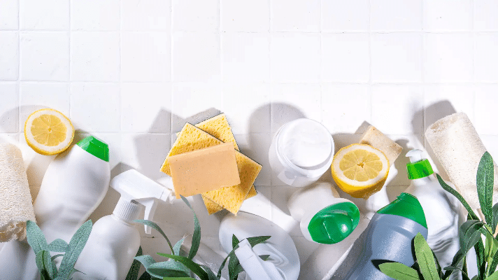 Eco friendly cleaning products - brushes, sponges, soap, bottles with green leaves